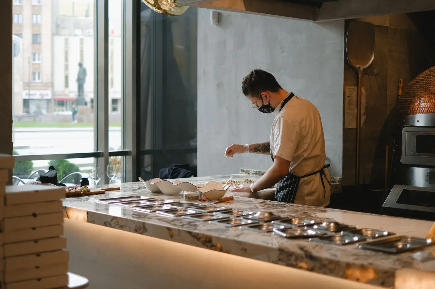 Le pizzaïolo prépare une commande derrière le comptoir