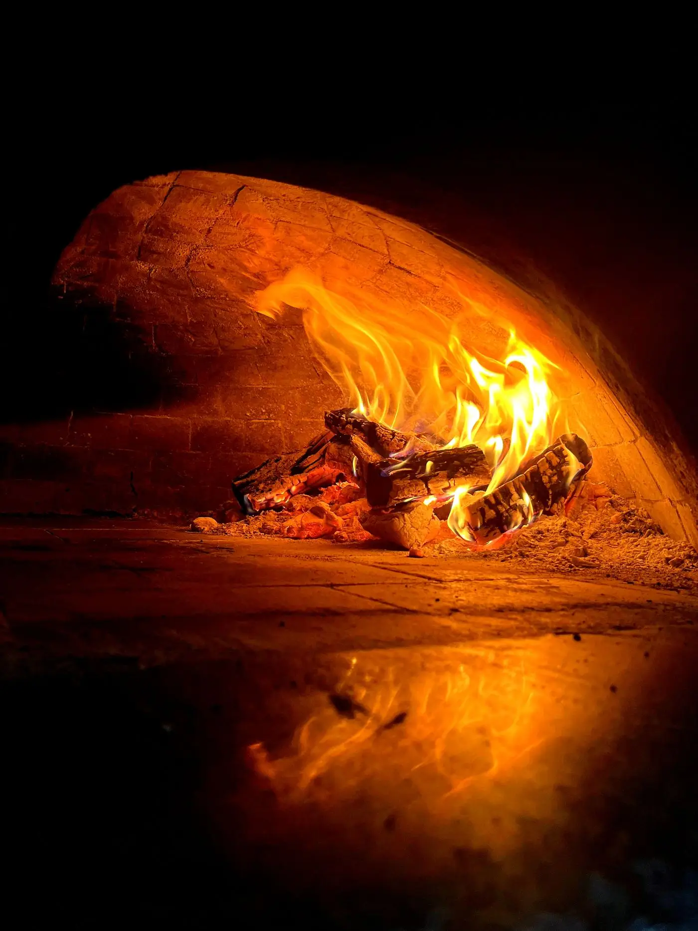 Les flammes du four à bois en pleine chauffe